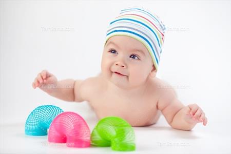 تصویر با کیفیت پسر بچه با کلاه رنگی و فنر بازی